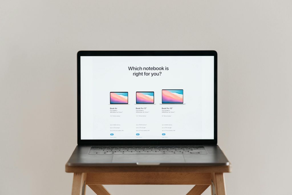 An open laptop on a wooden stool showing a notebook comparison chart, ideal for tech-focused imagery.
